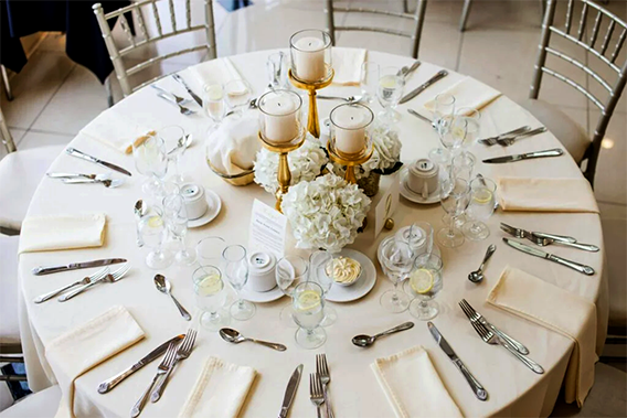 Bankett München. Ein runder Tisch, festlich gedeckt mit weißen und goldenen Servietten.
